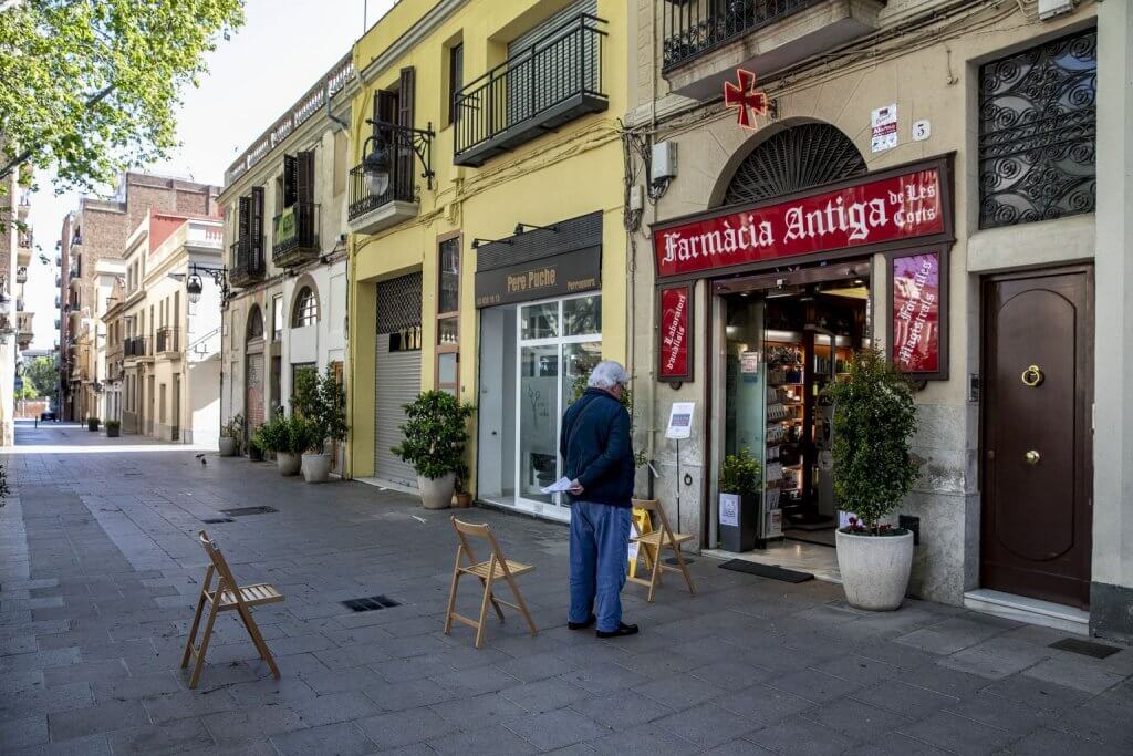 A man waits his turn outside a pharmacy in Barcelona