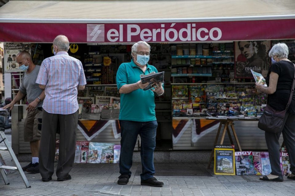 Citizens in Barcelona at a news kiosk