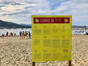 A beach sign explaining Covid-19 precautions