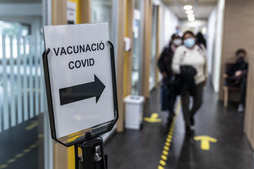 A sign in Catalan indicating the way for Covid vaccinations for essential and home care workers