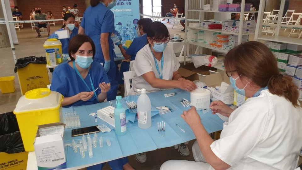 Health workers preparing vaccination jabs in Girona