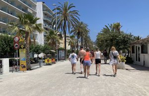Some tourists on the Sitges promenade in July.